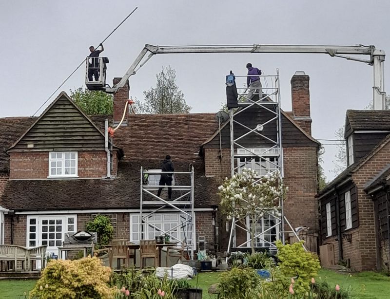 The Moss Cleaners using cherry picker and scaffolding to clean roof safely and professionally in Caterham, Surrey